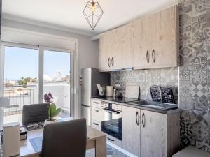 a kitchen with wooden cabinets and a dining table at JACUZZI penthouse - King's view in Artemida
