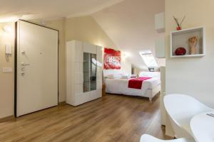 a large room with two beds and a mirror at Due cuori e una Mansarda - Vicino allo stadio in Monza
