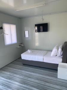 a bedroom with a bed and a tv on the wall at 1108 Pedas Village Resort in Pedas