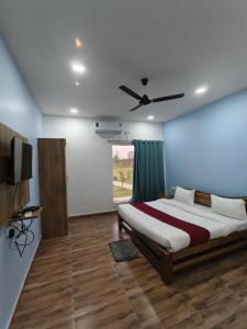 a bedroom with a bed and a ceiling fan at Somona Grandeur in Mandlā