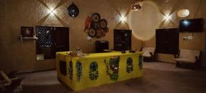 a living room with a yellow table in a room at Somona Grandeur in Mandlā
