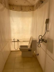 a small bathroom with a toilet and a shower at Somona Grandeur in Mandlā