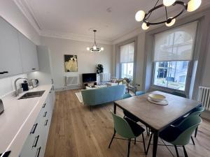 a kitchen and living room with a table and chairs at Halliford By Pureserviced in Plymouth