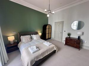 a bedroom with a bed and a green wall at Halliford By Pureserviced in Plymouth