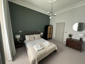 a bedroom with a bed with two towels on it at Halliford By Pureserviced in Plymouth +10 photos