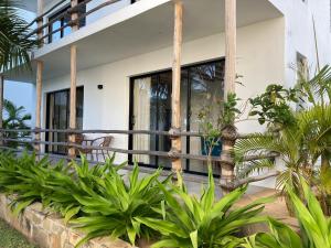 a house with plants in front of it at Ahadi Beachfront by YourHost 2 bedroom Kilifi in Mombasa