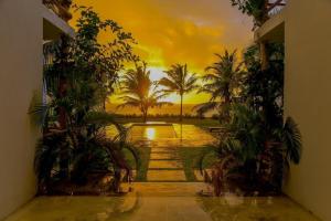 a hallway with a mural of palm trees and a sunset at Ahadi Beachfront by YourHost 2 bedroom Kilifi in Mombasa