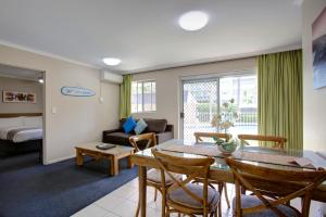 Beachpark Apartments Coffs Harbour في كوفس هاربور: غرفة معيشة مع طاولة وأريكة