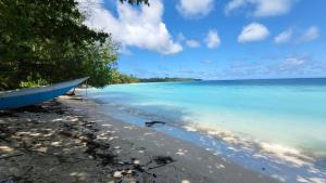 a boat sitting on the shore of a beach at Twin Palms Villa and Homestay in Tuapejat