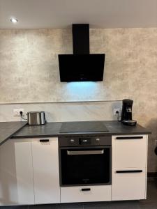 una cucina con forno a piano cottura in bianco e nero di Le repos du voyageur a Rolampont