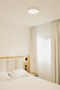 a bedroom with a white bed and a window at Miranove in Montpellier