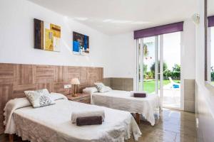a hotel room with two beds and a window at Villa Rachel in Es Mercadal +18 photos