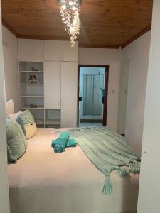 a bedroom with a large bed with a blue towel on it at Knysna's Rest in Brenton-on-Sea