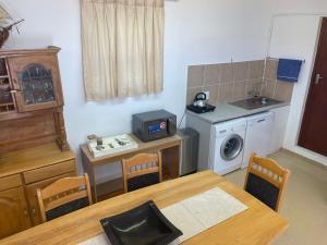 a kitchen with a table and a sink and a washing machine at Knysna's Rest in Brenton-on-Sea +3 photos
