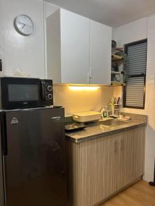 a kitchen with a black refrigerator and a microwave at Korean Themed 1BR Staycation in Marilao Bulacan in Marilao +7 photos