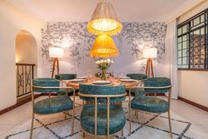 a dining room with a table and green chairs at Riverside Park Complex in Nairobi