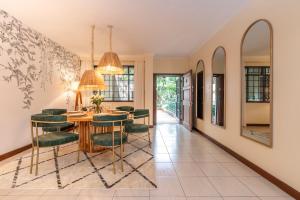a dining room with a table and green chairs at Riverside Park Complex in Nairobi