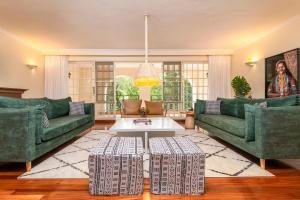 a living room with two green couches and a table at Riverside Park Complex in Nairobi +21 photos