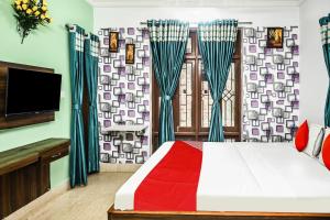 1 dormitorio con 1 cama, TV y cortinas en Hotel O Shraddha Residency 2, en Pānchuria 23 fotos más