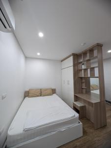 a small bedroom with a bed and a shelf at Era Apartment Lac Long Quan in Hanoi +33 photos