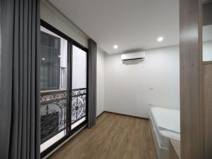 a room with a balcony with a bed and a window at Era Apartment Lac Long Quan in Hanoi