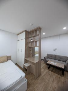 a bedroom with a bed and a couch at Era Apartment Lac Long Quan in Hanoi +33 photos