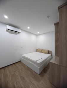 a white room with a bed and a tv at Era Apartment Lac Long Quan in Hanoi
