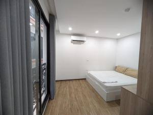 a small white room with a bed in it at Era Apartment Lac Long Quan in Hanoi