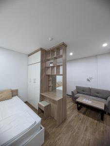 a bedroom with a bed and a couch at Era Apartment Lac Long Quan in Hanoi