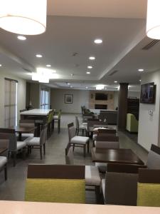 a dining room with tables and chairs and a cafeteria at Comfort Inn & Suites Snyder in Snyder