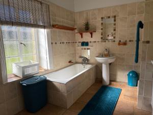 a bathroom with a tub and a sink at Echo Valley Guest Farm in Breyten +96 photos