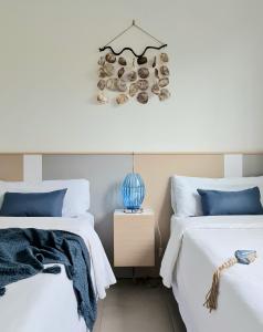 a bedroom with two beds with white sheets and blue pillows at Sea Arenales del Sol in Arenales del Sol +23 photos