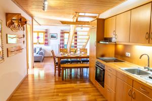 a kitchen with wooden cabinets and a dining room at Thalerbauer Ferienwohnungen in Wackersberg