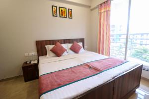 a bedroom with a large bed with a window at Pinaki Comfort Stay Vile Parle - Near Airport in Mumbai