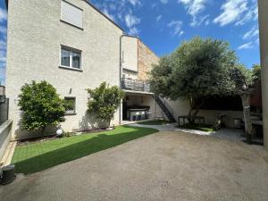 a house with a courtyard with a grass yard at Spacieuse maison de vacances à proximité des plages in Torreilles