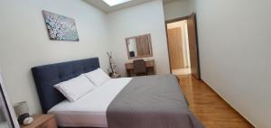 ピレウスにあるNear the Pasha Limaniのベッドルーム1室(大型ベッド1台、青いヘッドボード付)