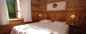 a bedroom with a white bed and a window at Chalet Hotel d Ailefroide in Ailefroide