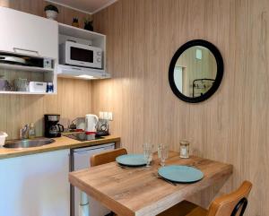 eine Küche mit einem Holztisch und einem Spiegel in der Unterkunft Studio en bois, confort et modernité in Saint-Brevin-les-Pins + 9 Fotos