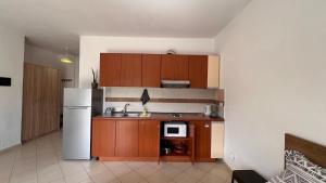 a kitchen with wooden cabinets and a white refrigerator at Kate Apartment in Durrës