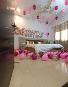 a room with pink balloons and a happy birthday sign at GLOBAL Luxury Stay in Gurgaon