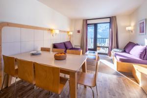 a living room with a table and a couch at Résidence Pierre & Vacances La Forêt in Flaine