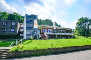 a building with a grass field in front of it at Jugendherberge Bad Urach in Bad Urach