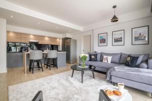 a living room with a couch and a table at Riverside Square By YourHost Nairobi in Nairobi