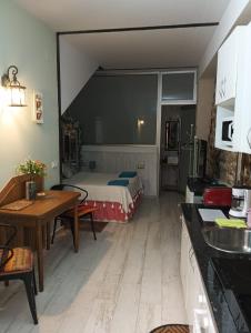 kuchnia z pokojem z łóżkiem i stołem w obiekcie APARTAMENTO ESTUDIO AS ANDURIÑAS w mieście San Martín de Trevejo