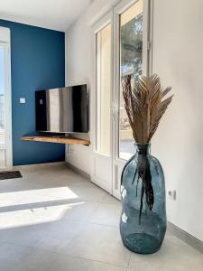 Un jarrón azul con una planta en una habitación en Magnifique Villa avec Spa à COMPIEGNE - Beautiful villa with hot tub, Compiegne, en Compiègne