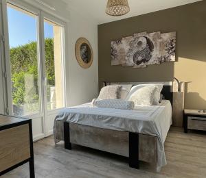Un dormitorio con una cama y una ventana grande. en Magnifique Villa avec Spa à COMPIEGNE - Beautiful villa with hot tub, Compiegne, en Compiègne 26 fotos más