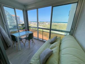 a living room with a couch and a table at évasion marine - vue mer - plage in Le Barcarès