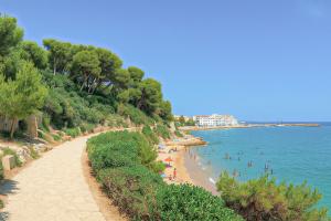 a beach with people swimming in the water at Arc de Bará Camping & Bungalows in Roda de Bará