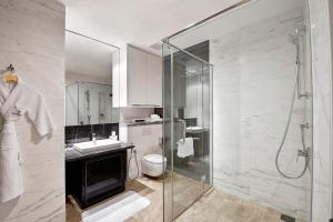 a bathroom with a shower, sink, and toilet at THE FACE Suites in Kuala Lumpur