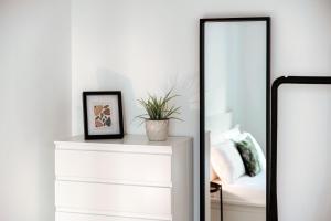 a mirror next to a white dresser in a bedroom at Como Lago Apartment by Quokka 360 - Close to the Lake and Train Station in Como